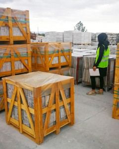 Inspector checking wooden export crates at a stone yard in Turkey